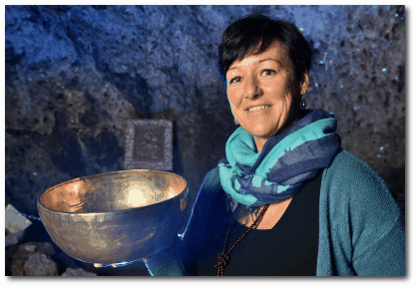 Katrin Leutbecher hält eine Klangschale in einer Hand - sie steht in der Marienglas-Höhle