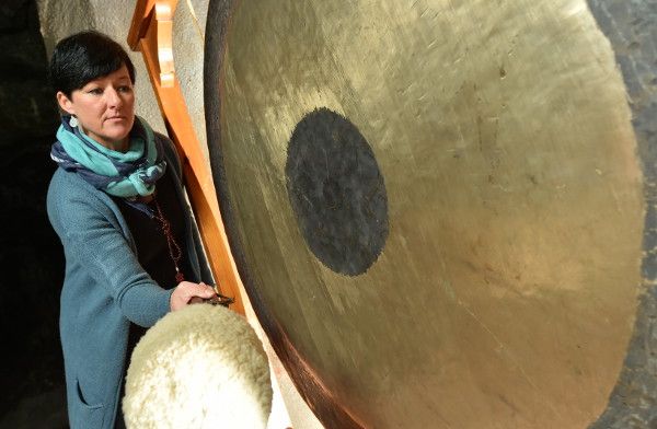 Katrin Leutbecher schlägt den großen Gong in der Marienglas-Höhle an und lauscht den Schwingungen.