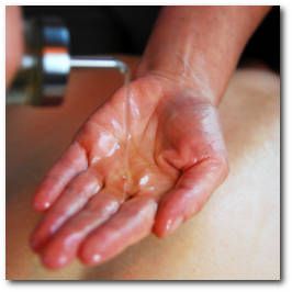 Katrin Leutbecher gibt angewärmtes Massageöl auf ihre Hand